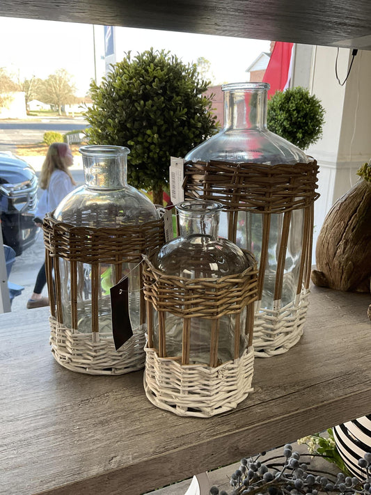 Clear glass bottle in woven rattan basket