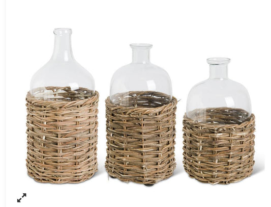 Clear glass bottle in woven rattan baskets