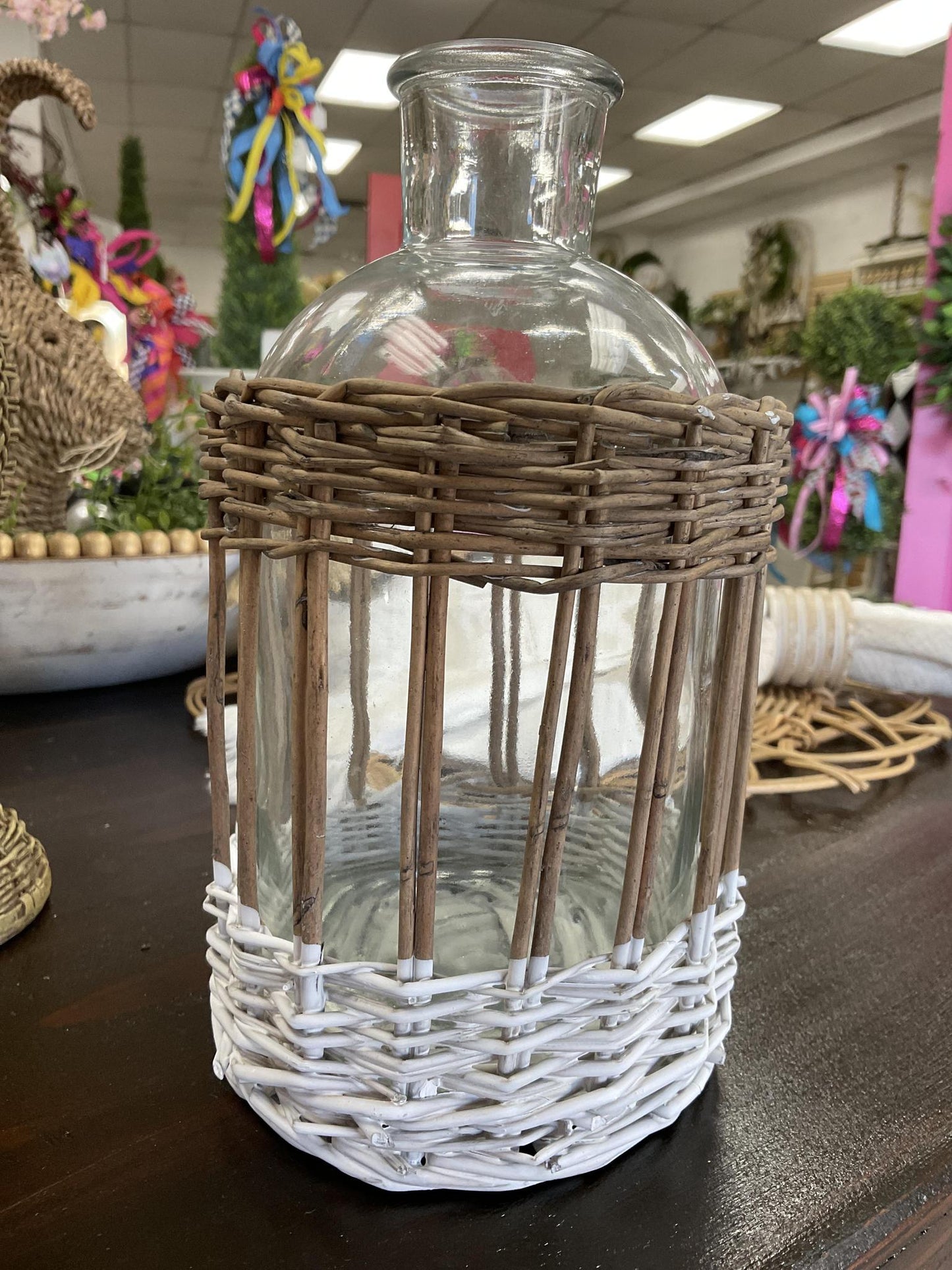 Clear glass bottle in woven rattan basket