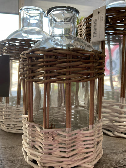 Clear glass bottle in woven rattan basket